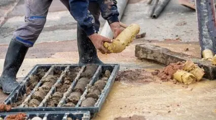 Man inspecting collected soil sample|Man inspecting collected soil sample|Borehole Log Template|