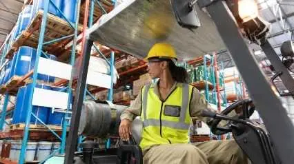 Mujer utilizando una carretilla elevadora de forma segura