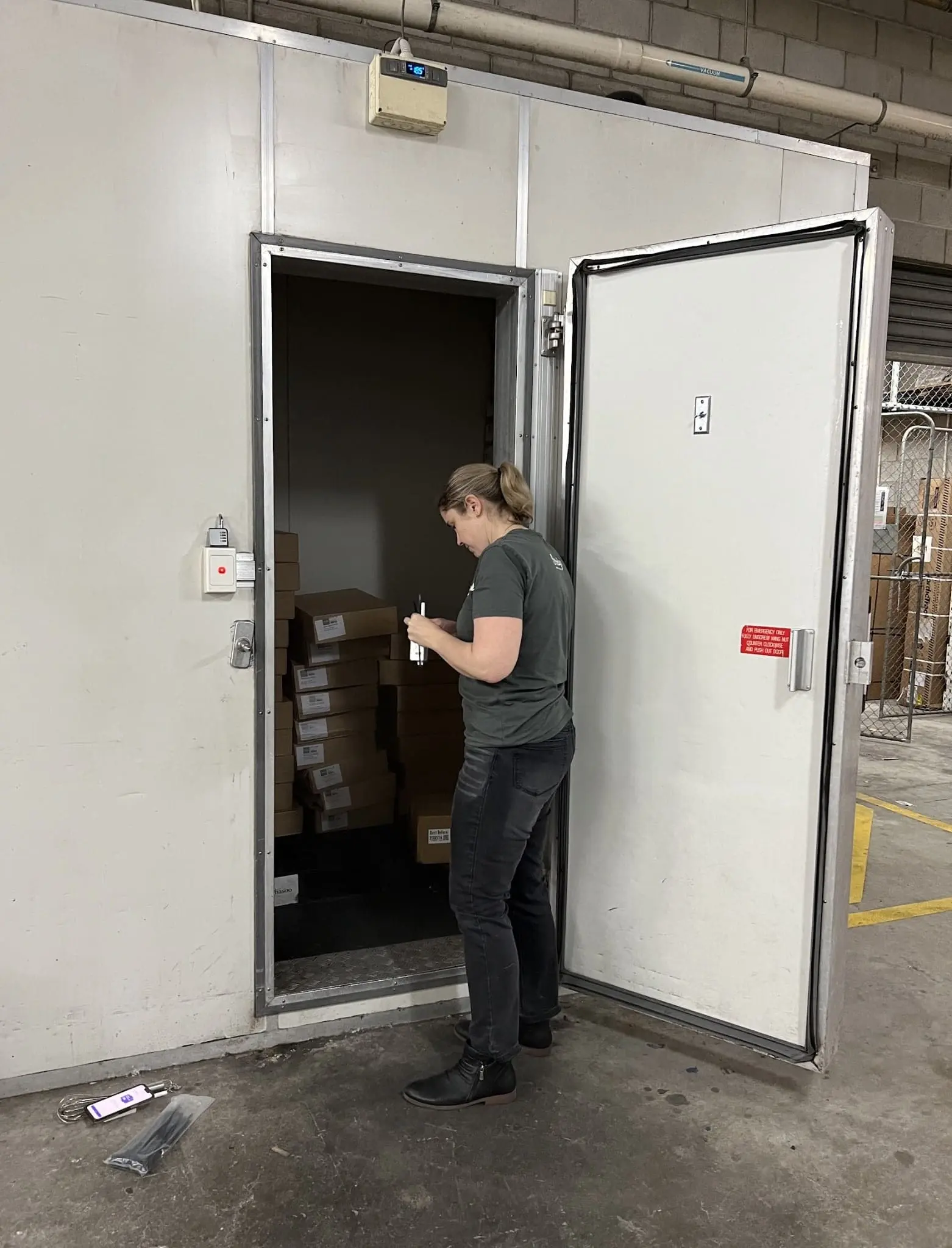 Woman standing outside industry fridge