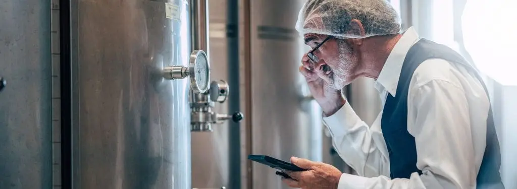 a facility manager checking liquid temperatures on a warehouse using a facility monitoring software|eMaint|FMX|Honeywell Forge