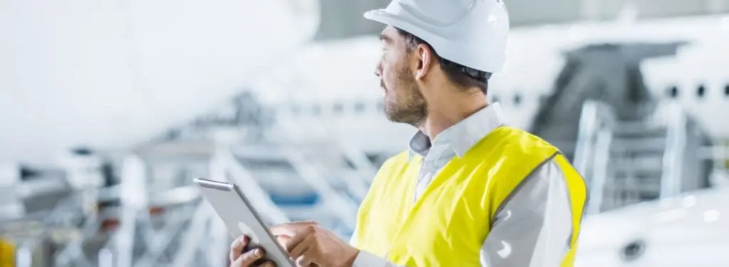 an aircraft maintenance engineer checking aircraft before operation using an aviation safety management software on a tablet|SMS Pro|Baldwin