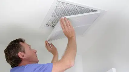 an IAQ inspector checking HVAC filters during an IAQ assessment as a task listed on an indoor air quality assessment checklist|Indoor Air Quality Assessment Checklist Sample Report|Indoor Air Quality Assessment Checklist