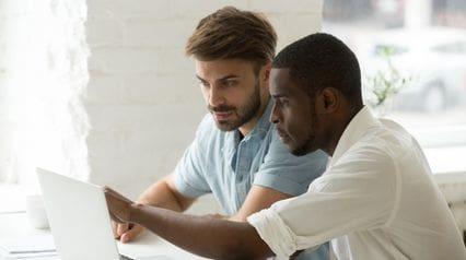 two professionals conducting risk identification using a tablet