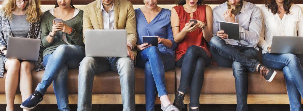 a group of employees using business intelligence tools on laptops, phones, and tablets