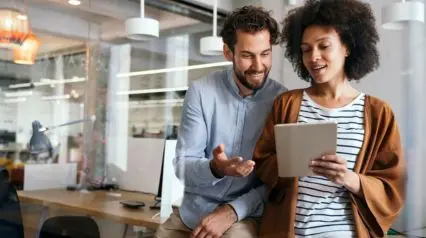 two people using a legal compliance checklist on a tablet and discussing it