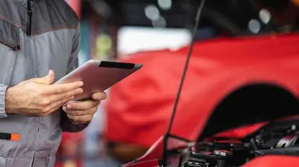 car inspector using a dot new entrant safety checklist in a garage