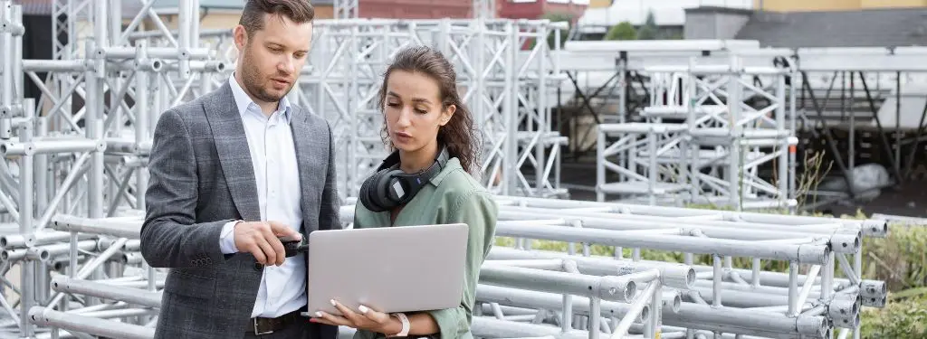 two people using an event management software while setting up the venue