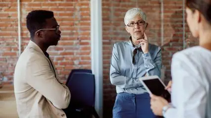 people discussing changes in the company with a change management checklist in hand