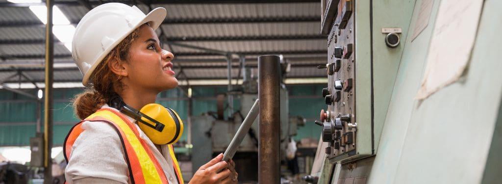 an industrial worker inspecting equipment using an enterprise facility management software on a tablet device|eFACiLiTY|Facilio|IBM Tririga|iLab by Agilent|QuickFMS|Ramco