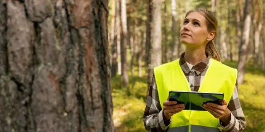 a sustainability manager auditing an organization's CSR practices using sustainability audit checklist on a tablet