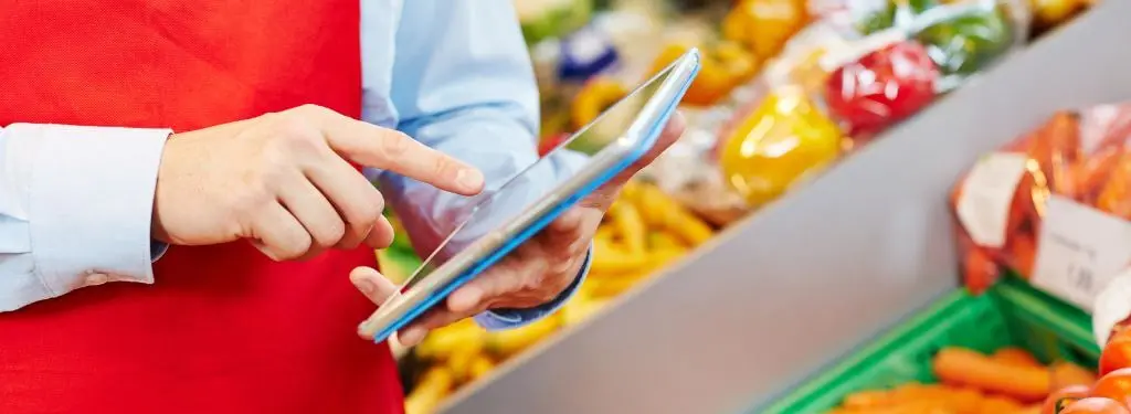 retail worker using a retail erp software on their tablet