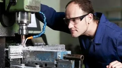 worker drilling metal in the workshop